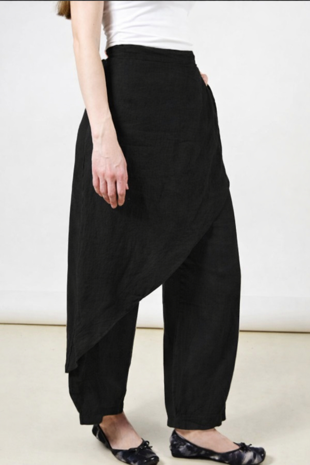 Person wearing black wide-leg pants on a plain background